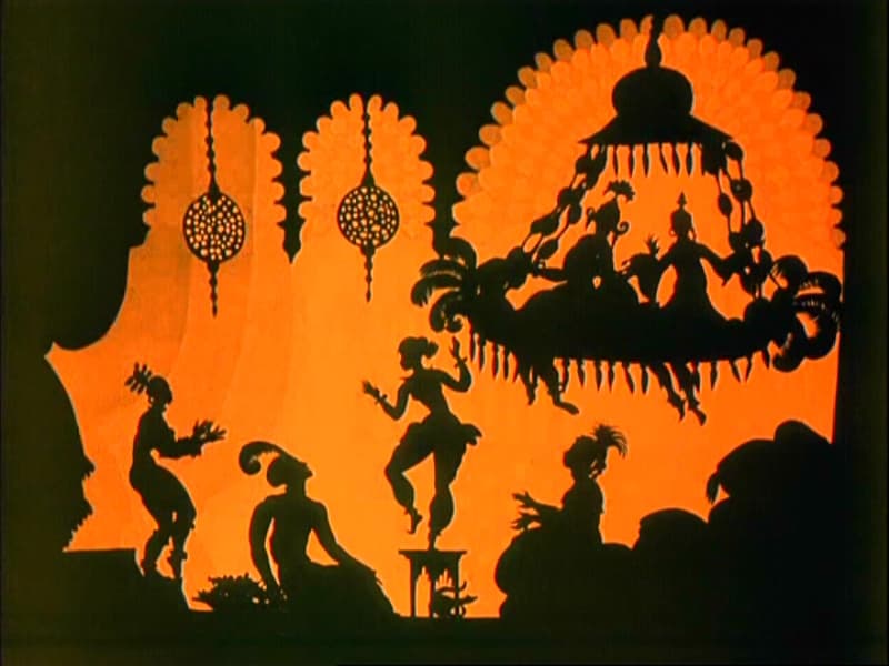 A black silhouette figure from the 1926 animated film The Adventures of Prince Achmed, set against a decorative patterned background.