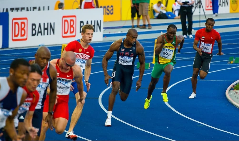 A sprinter in mid-stride on a track, one foot planted, body upright, during a 200 m race.