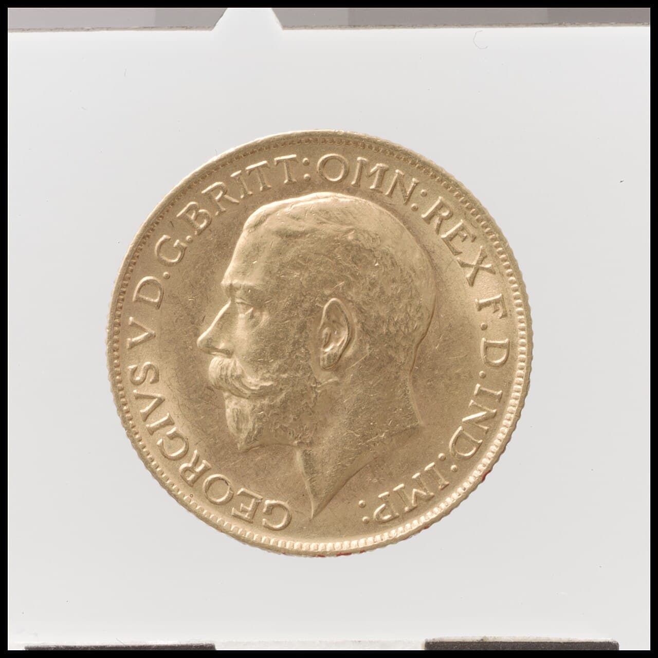 A gold sovereign coin showing the profile of King George V.