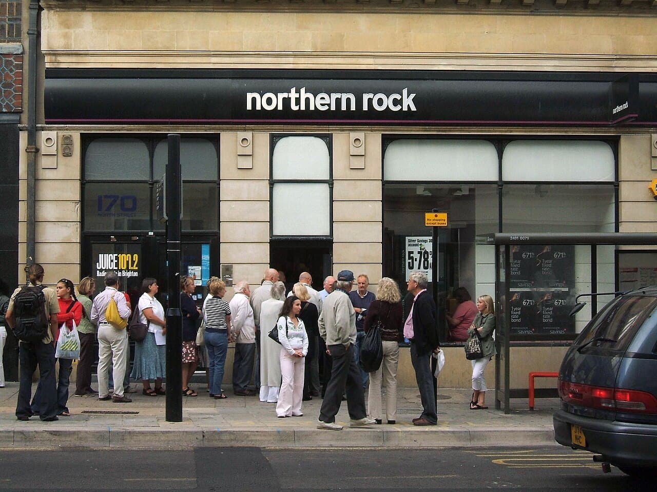 A long queue of people standing outside a Northern Rock bank branch in 2007, waiting to withdraw their savings.