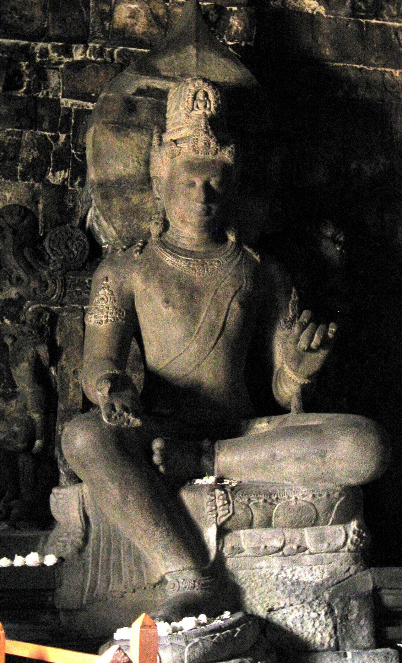 Large stone statue of the bodhisattva Avalokiteshvara, seated on a lotus throne and richly adorned, at the Candi Mendut temple in Java.