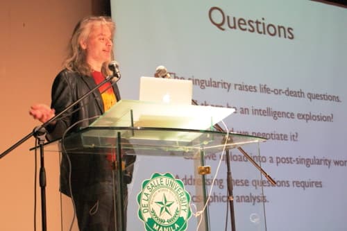Photograph of philosopher David Chalmers, a man with long hair, giving a talk.