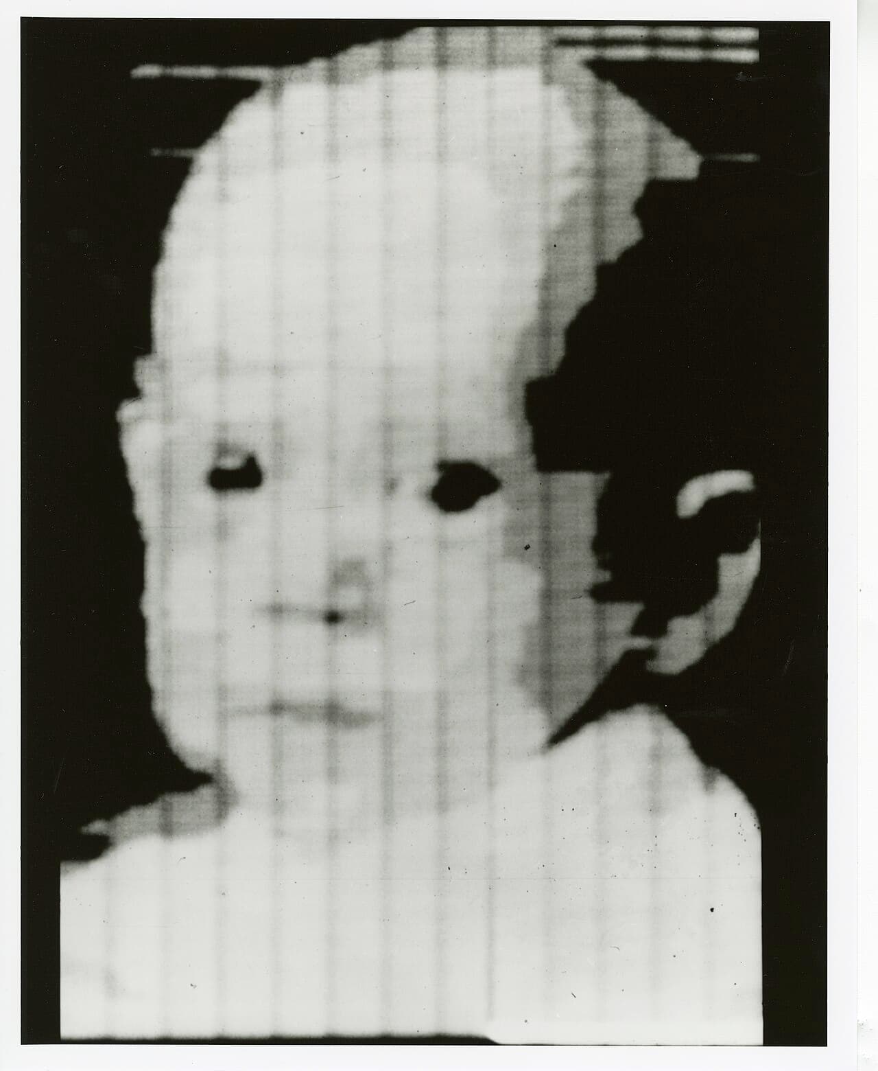 Grainy black-and-white square image of a baby's face, made of visible square pixels.