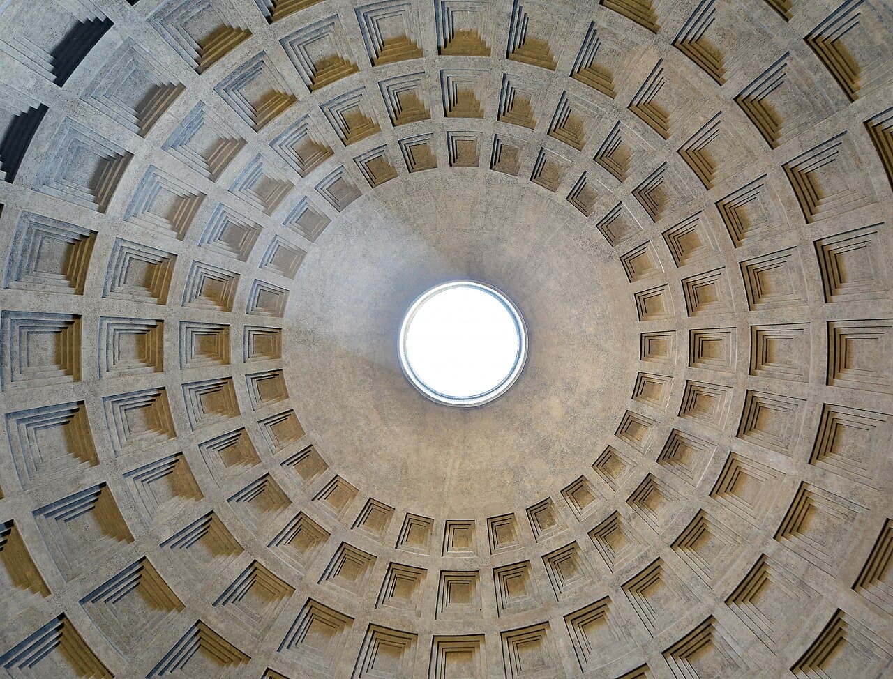 The coffered concrete dome of the Pantheon in Rome, viewed from below, with a circular opening, the oculus, at its center letting in light.