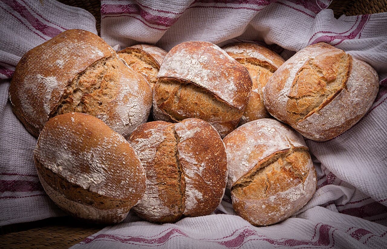A sliced loaf of homemade sourdough bread showing an airy crumb full of holes