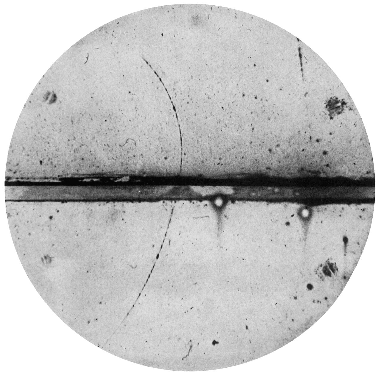 Cloud-chamber photograph showing the curved track of the first observed positron, with a lead plate across the middle.