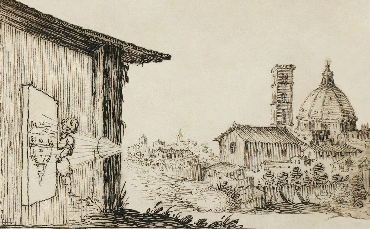 Old engraving of a room with a hole in the wall projecting an upside-down image of a city with a large dome onto the opposite wall.