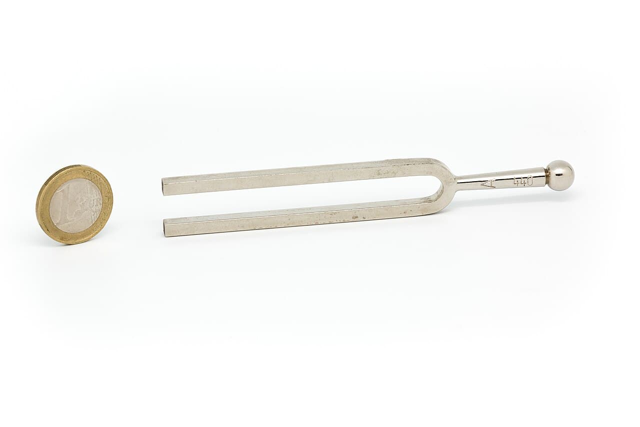 A chromed tuning fork with square prongs, stamped for 440 Hz.